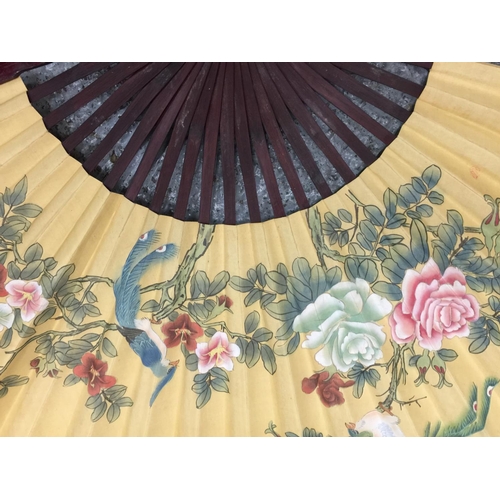 180 - TWO LARGE HANDPAINTED EASTERN FANS AND A HANDPAINTED PARASOL