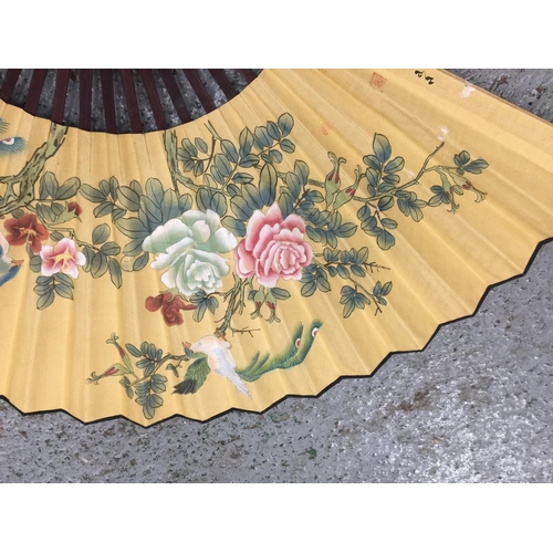 180 - TWO LARGE HANDPAINTED EASTERN FANS AND A HANDPAINTED PARASOL