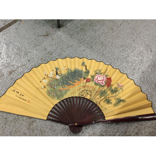 180 - TWO LARGE HANDPAINTED EASTERN FANS AND A HANDPAINTED PARASOL