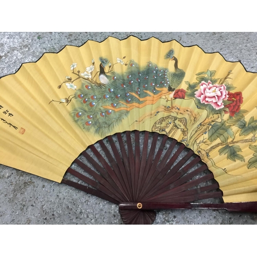 180 - TWO LARGE HANDPAINTED EASTERN FANS AND A HANDPAINTED PARASOL