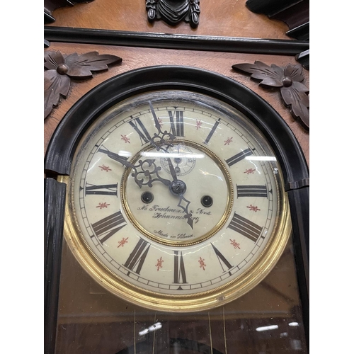 266 - AN ORNATE DOUBLE WEIGHT VIENNA WALL CLOCK IN A MAHOGANY CASE