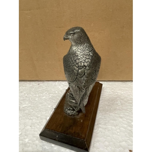 519 - A PEWTER FIGURE OF A FALCON IN A WOODEN BASE