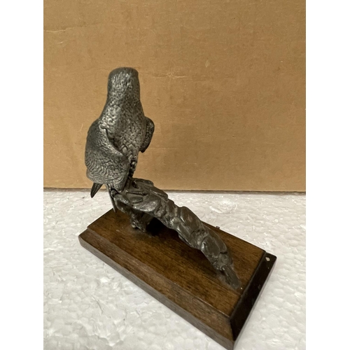 519 - A PEWTER FIGURE OF A FALCON IN A WOODEN BASE