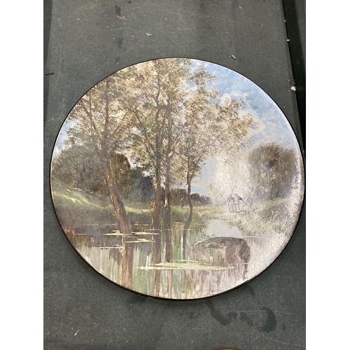 232 - A LARGE CERAMIC WALL PLATE WITH A RIVER SCENE - SIGNED DIAMETER 33CM