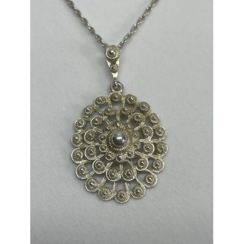 523 - A MARKED SILVER NECKLACE WITH A LARGE DECORATIVE SILVER PENDANT IN A PRESENTATION BOX