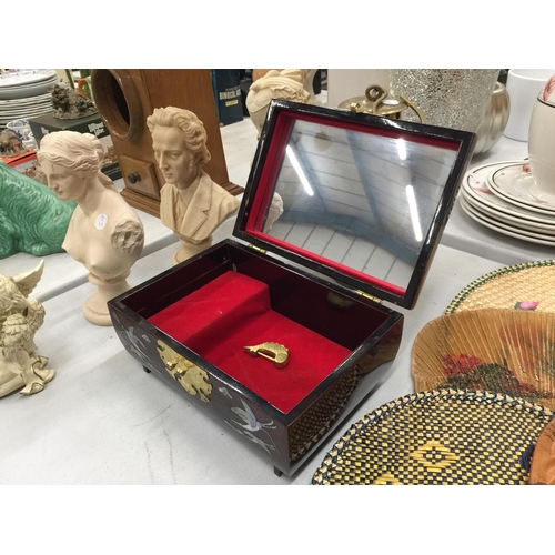 160 - AN ORIENTAL STYLE MUSICAL JEWELLERY BOX WITH CRIMSON LACQUER AND MOTHER OF PEARL STORK DECORATION