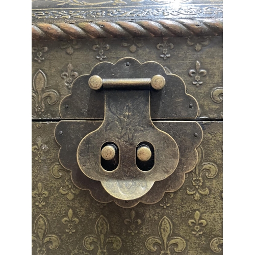 318 - A VINTAGE WOODEN 'BRONZED' STORAGE BOX WITH METAL HANDLES AND FASTENER AND FLEUR DE LYS PATTERN WIDT... 