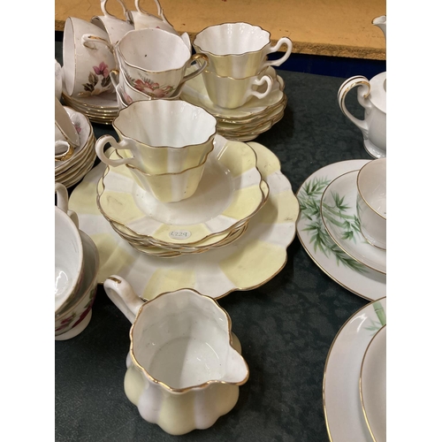 261 - A QUANTITY OF VINTAGE TEAWARE TO INCLUDE A YELLOW AND WHITE FLUTED DESIGN, ROSE PATTERNED, ETC - CUP... 