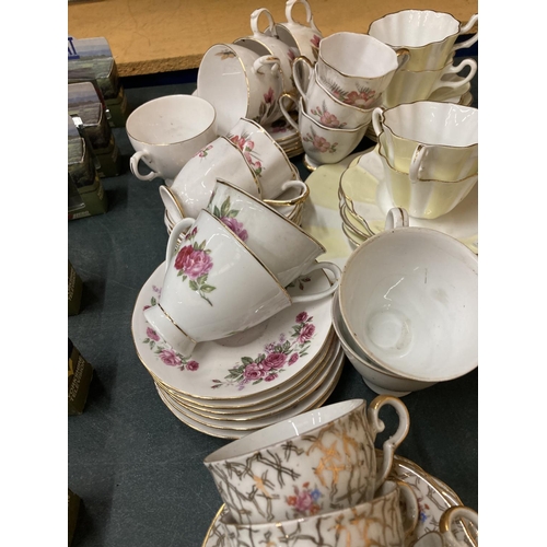 261 - A QUANTITY OF VINTAGE TEAWARE TO INCLUDE A YELLOW AND WHITE FLUTED DESIGN, ROSE PATTERNED, ETC - CUP... 