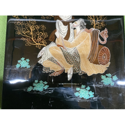 944 - AN ASIAN STYLE LACQUERED PLAQUE OF A MAN AND A LADY