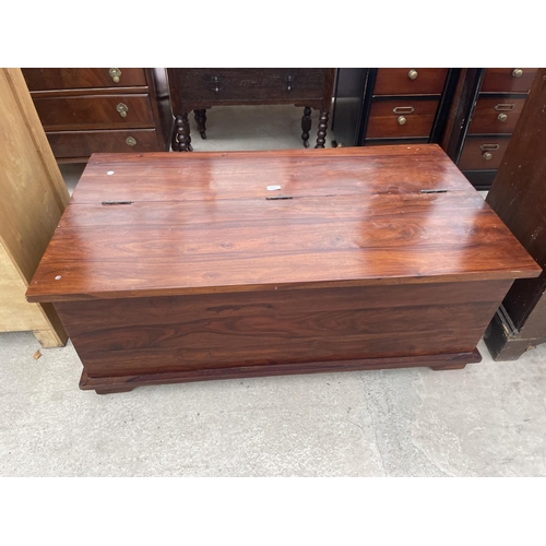 2665 - A MODERN HARDWOOD COFFEE TABLE WITH HINGED LID AND ENCLOSING TWELVE DRAWERS TO OTHER SIDE, 48X26