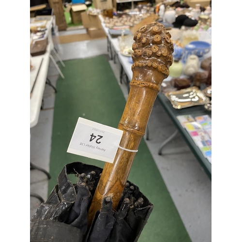 24 - A VINTAGE WOODEN HANDLED UMBRELLA WITH COVER