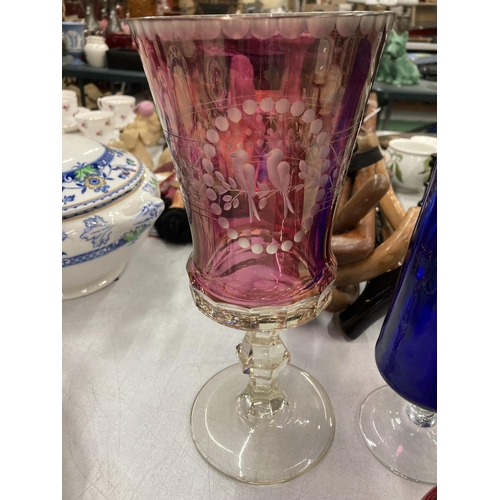 196 - THREE PIECES OF CRANBERRY GLASS TO INCLUDE A FOOTED VASE WITH EMBOSSED BIRD DECORATION, A BASKET BOW... 