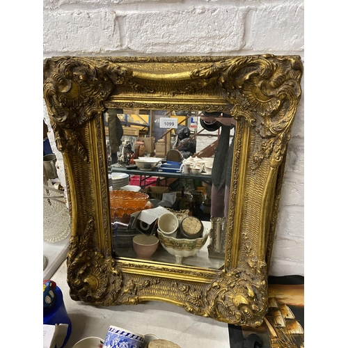 1099 - AN ORNATE RECTANGULAR GILT FRAMED MIRROR