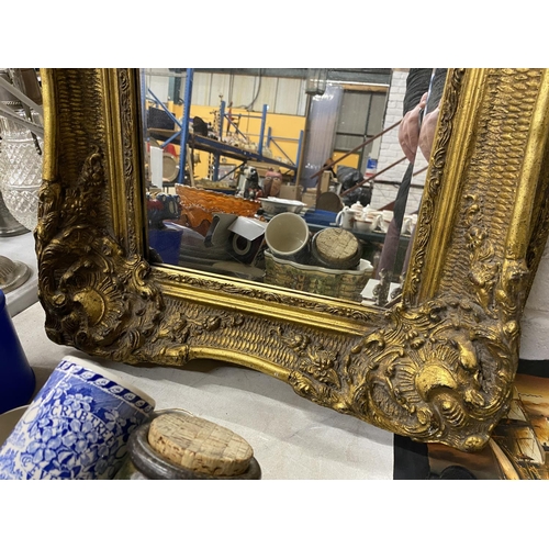 1099 - AN ORNATE RECTANGULAR GILT FRAMED MIRROR