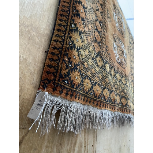 2200 - A LARGE BURNT ORANGE PATTERNED FRINGED RUG