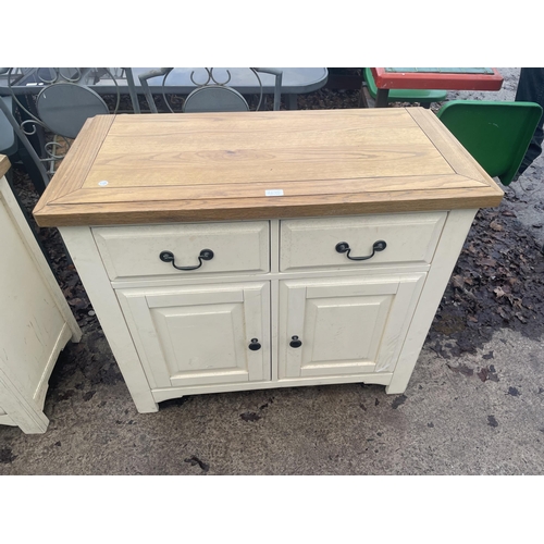 2675 - A MODERN OAK AND CREAM SIDEBOARD WITH TWO DOORS AND TWO DRAWERS - 99 CM X 47 CM X 85 CM HIGH