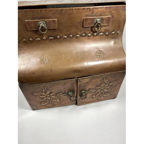 31 - AN ARTS AND CRAFTS 1912 COPPER DESKSTAND WITH LIFT UP TOP SECTION, TWO SMALL DRAWERS AND LOWER DOORS... 