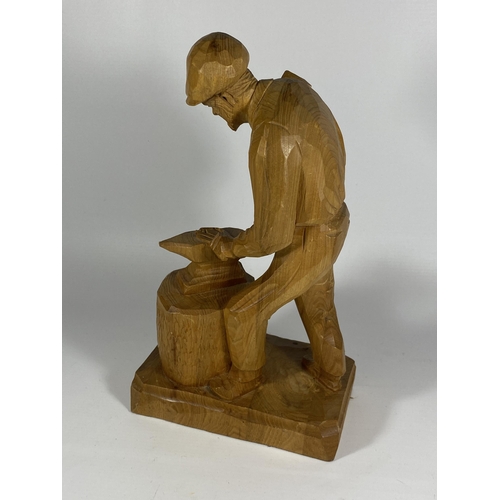 45 - A CARVED WOODEN MODEL OF A BLACKSMITH