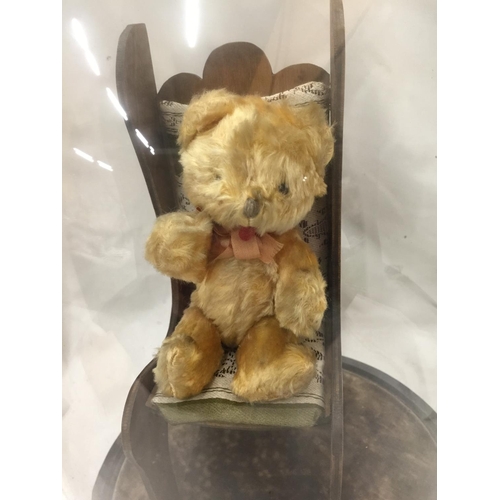 139 - A SMALL TEDDY ON A CHAIR IN A GLASS DOME