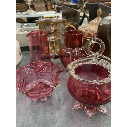 195 - A PAIR OF CRANBERRY GLASS JUGS HEIGHT 16CM