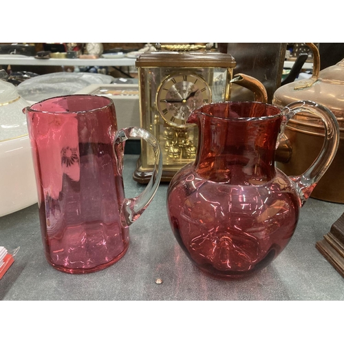 195 - A PAIR OF CRANBERRY GLASS JUGS HEIGHT 16CM