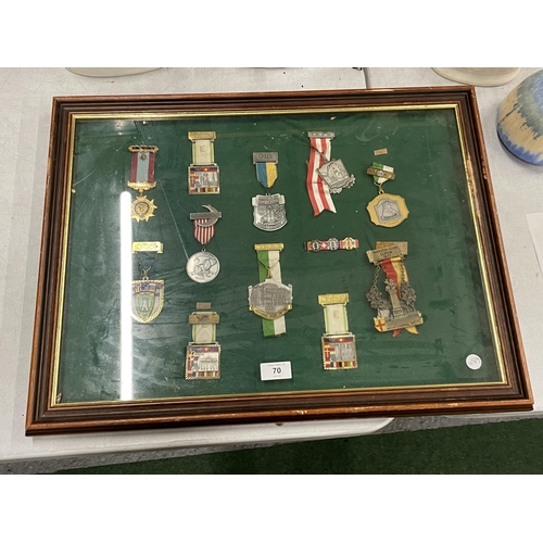 70 - A WOODEN AND GLASS DISPLAY CASE CONTAINING ASSORTED MILITARY MEDALS