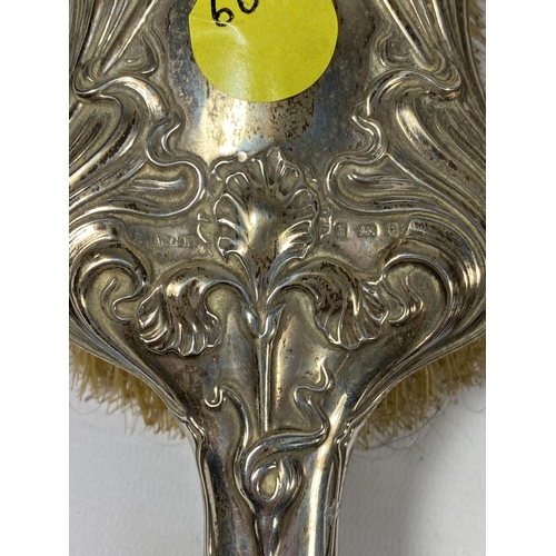 94 - AN EDWARDIAN SILVER BACKED ART NOUVEAU TWO PIECE DRESSING SET COMPRISING BRUSH AND MIRROR, HALLMARKS... 