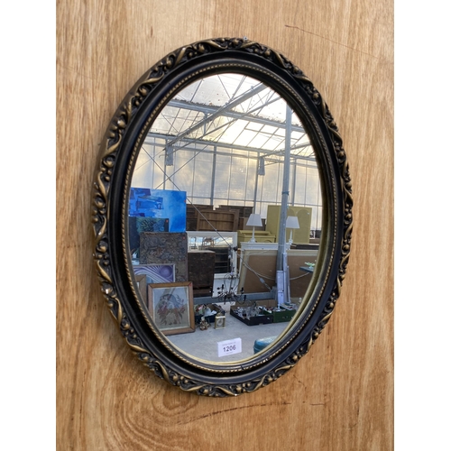 1206 - A SMALL OVAL GILT AND BLACK FRAMED WALL MIRROR