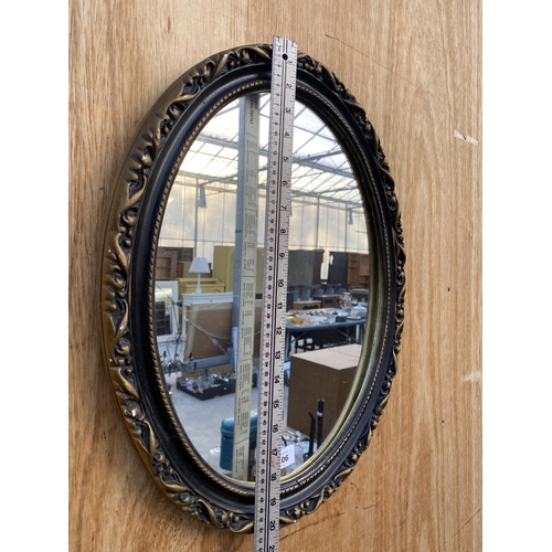 1206 - A SMALL OVAL GILT AND BLACK FRAMED WALL MIRROR