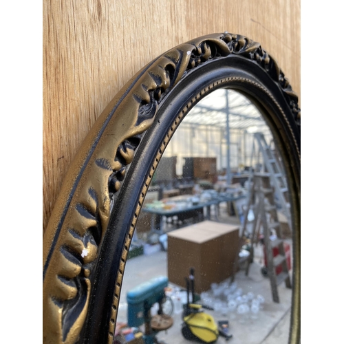 1206 - A SMALL OVAL GILT AND BLACK FRAMED WALL MIRROR