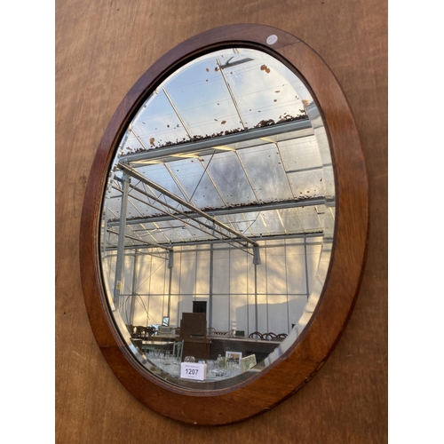 1207 - AN OVAL MAHOGANY FRAMED BEVELED EDGE WALL MIRROR