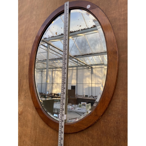 1207 - AN OVAL MAHOGANY FRAMED BEVELED EDGE WALL MIRROR