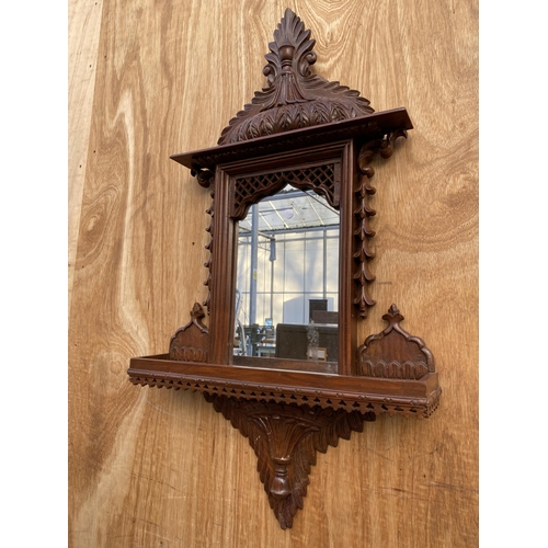 1210 - A DECORATIVE WOODEN FRAMED WALL MIRROR WITH LOWER SHELF