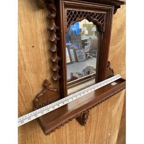 1210 - A DECORATIVE WOODEN FRAMED WALL MIRROR WITH LOWER SHELF