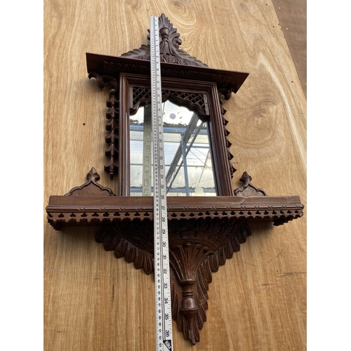 1210 - A DECORATIVE WOODEN FRAMED WALL MIRROR WITH LOWER SHELF