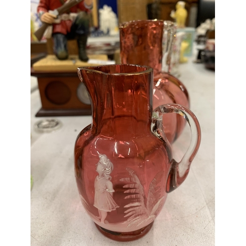 154 - THREE PIECES OF MARY GREGORY STYLE JUGS TO INCLUDE TWO CRANBERRY AND ONE LEMON COLOURED