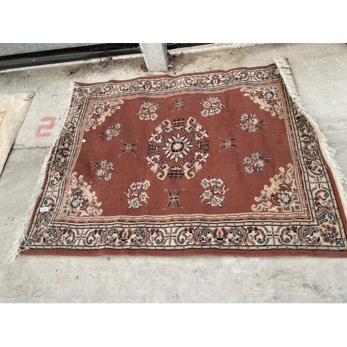 2193 - A SMALL ORANGE PATTERNED FRINGED RUG