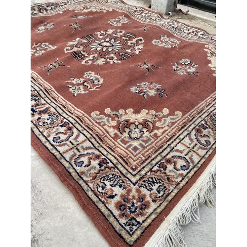 2193 - A SMALL ORANGE PATTERNED FRINGED RUG