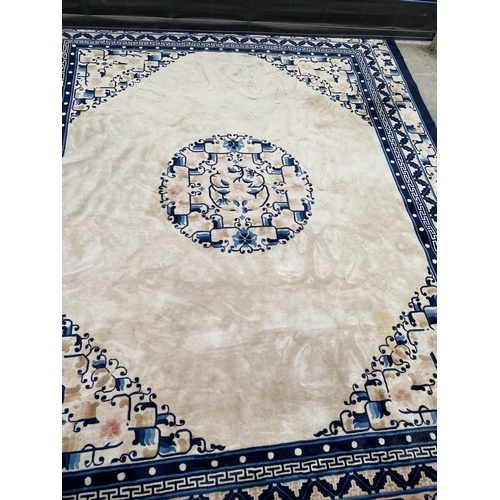 2194 - A LARGE CREAM AND BLUE PATTERNED FRINGED RUG