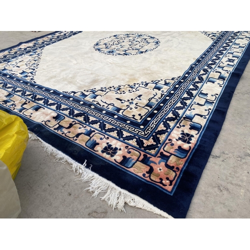 2194 - A LARGE CREAM AND BLUE PATTERNED FRINGED RUG