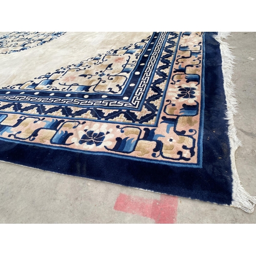 2194 - A LARGE CREAM AND BLUE PATTERNED FRINGED RUG