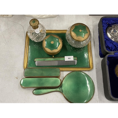 44 - A VINTAGE GREEN ENAMEL BACKED DRESSING TABLE SET COMPRISING TRAY, BRUSHES, MIRROR AND POTS