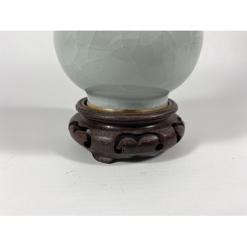 368 - A CHINESE CELADON GROUND PORCELAIN BOTTLE VASE ON CARVED WOODEN STAND, HEIGHT OF VASE 18CM