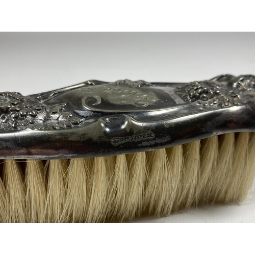 692 - A STERLING SILVER BACKED HAIRBRUSH