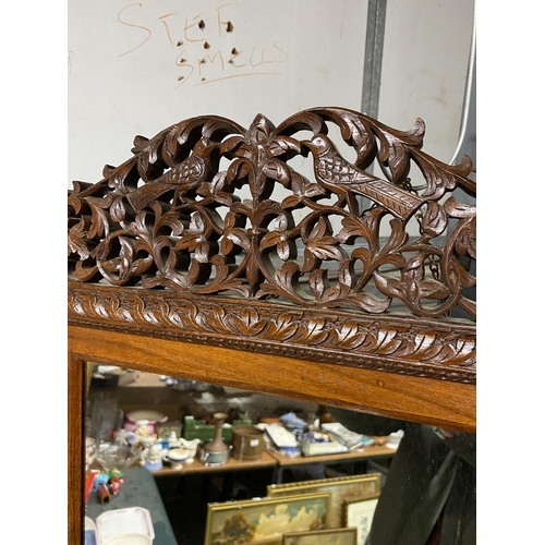 1098 - A 20TH CENTURY HARDWOOD WALL MIRROR WITH CARVED FOLIATE AND ANIMAL AND BIRD DECORATION 69CM X 56CM