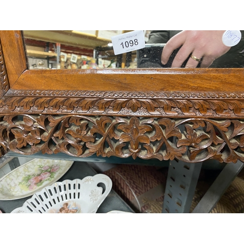 1098 - A 20TH CENTURY HARDWOOD WALL MIRROR WITH CARVED FOLIATE AND ANIMAL AND BIRD DECORATION 69CM X 56CM