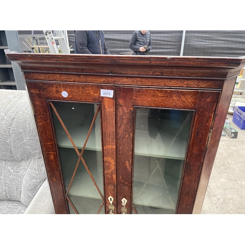 2579 - A VICTORIAN OAK TWO DOOR GLAZED CORNER CUPBOARD ON OPEN BASE, 28