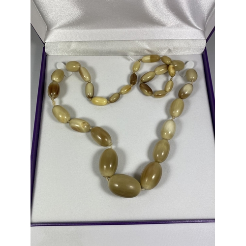 600 - AN AMBER STYLE NECKLACE IN A PRESENTATION BOX