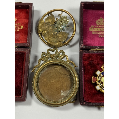 564 - A GROUP OF FOUR ITEMS TO INCLUDE TWO VINTAGE BOXED BADGES, GILT MINIATURE FRAME AND FLORAL GILT BROO... 